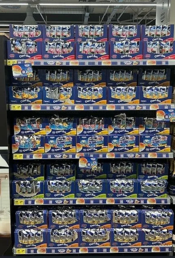 A shop shelf stocked with Capri Sun products